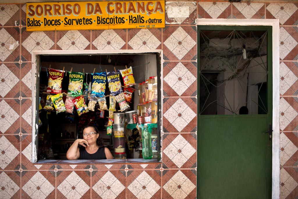Woman at window counter of neighborhood store in Brazil.