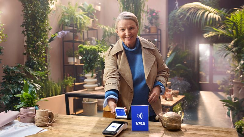 lady paying with Visa on mobile in store