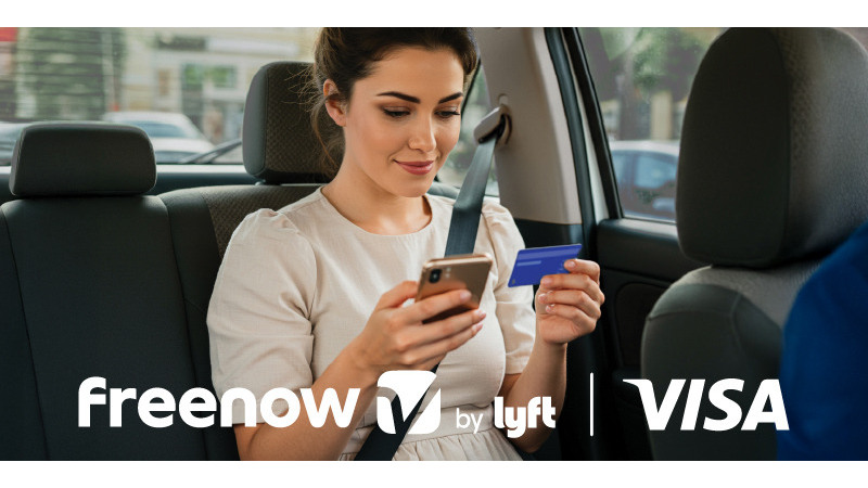woman looking at phone and visa card + Freenow by Lyft and Visa logos