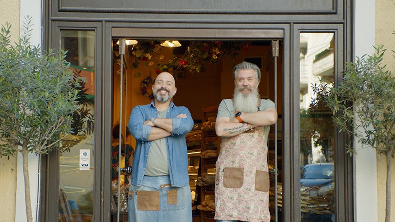 Men in aprons outside shop