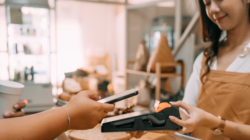 women taking a payment using a phone